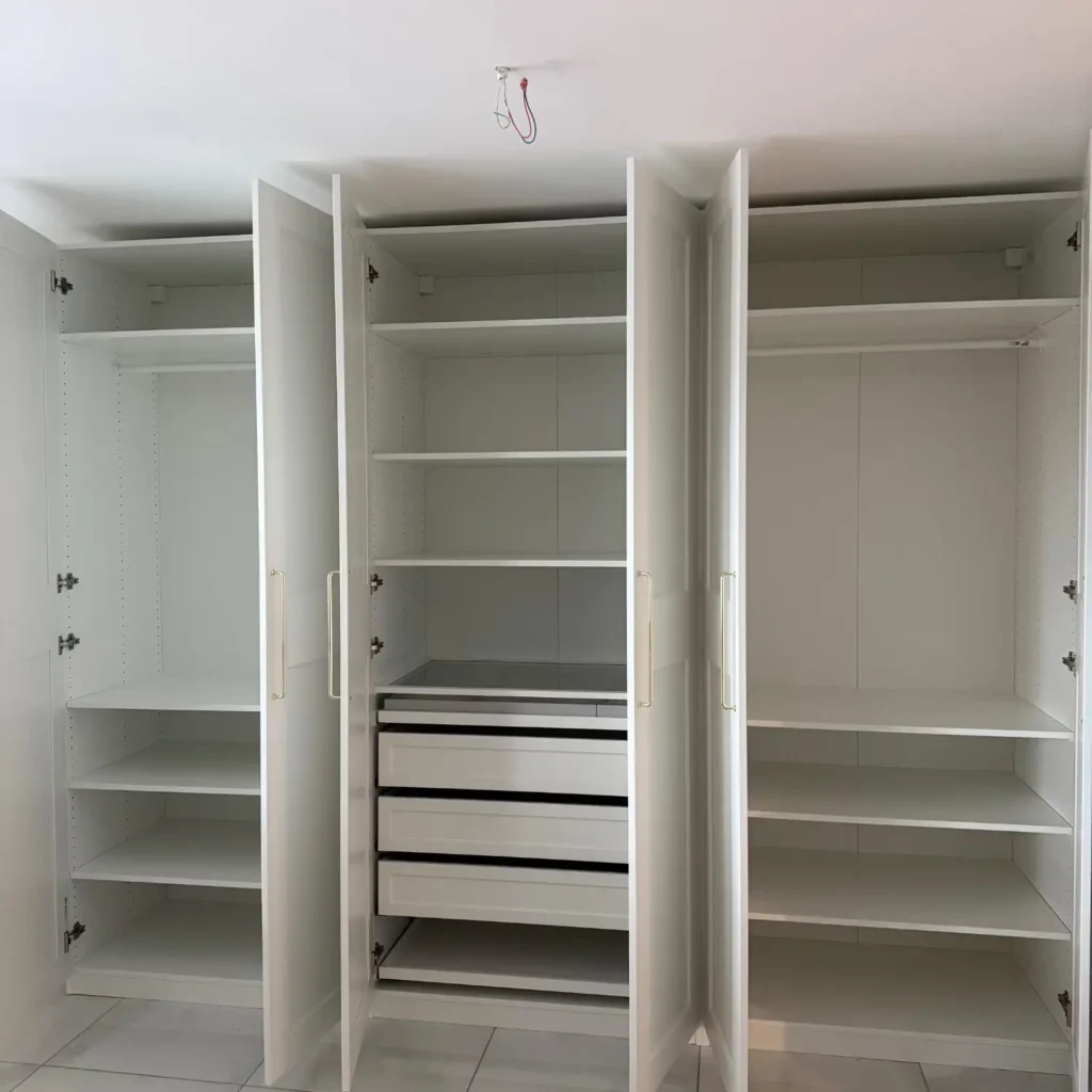 Montage eines großen weißen Kleiderschranks mit Schiebetüren in einer Wohnung bei Zürich