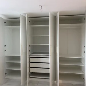 Montage eines großen weißen Kleiderschranks mit Schiebetüren in einer Wohnung bei Zürich