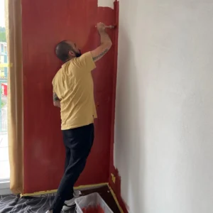 Javier bei Malerarbeiten – rote Wand in einer Wohnung in Zürich