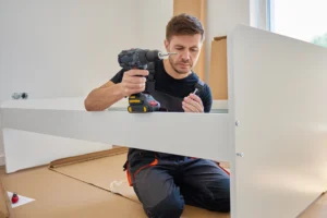 Professional handyman assembling IKEA furniture with electric drill in Zurich apartment.