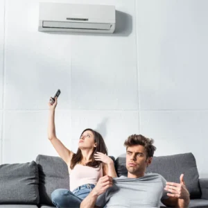 Couple sitting on a couch using air conditioning in a rental apartment in Switzerland