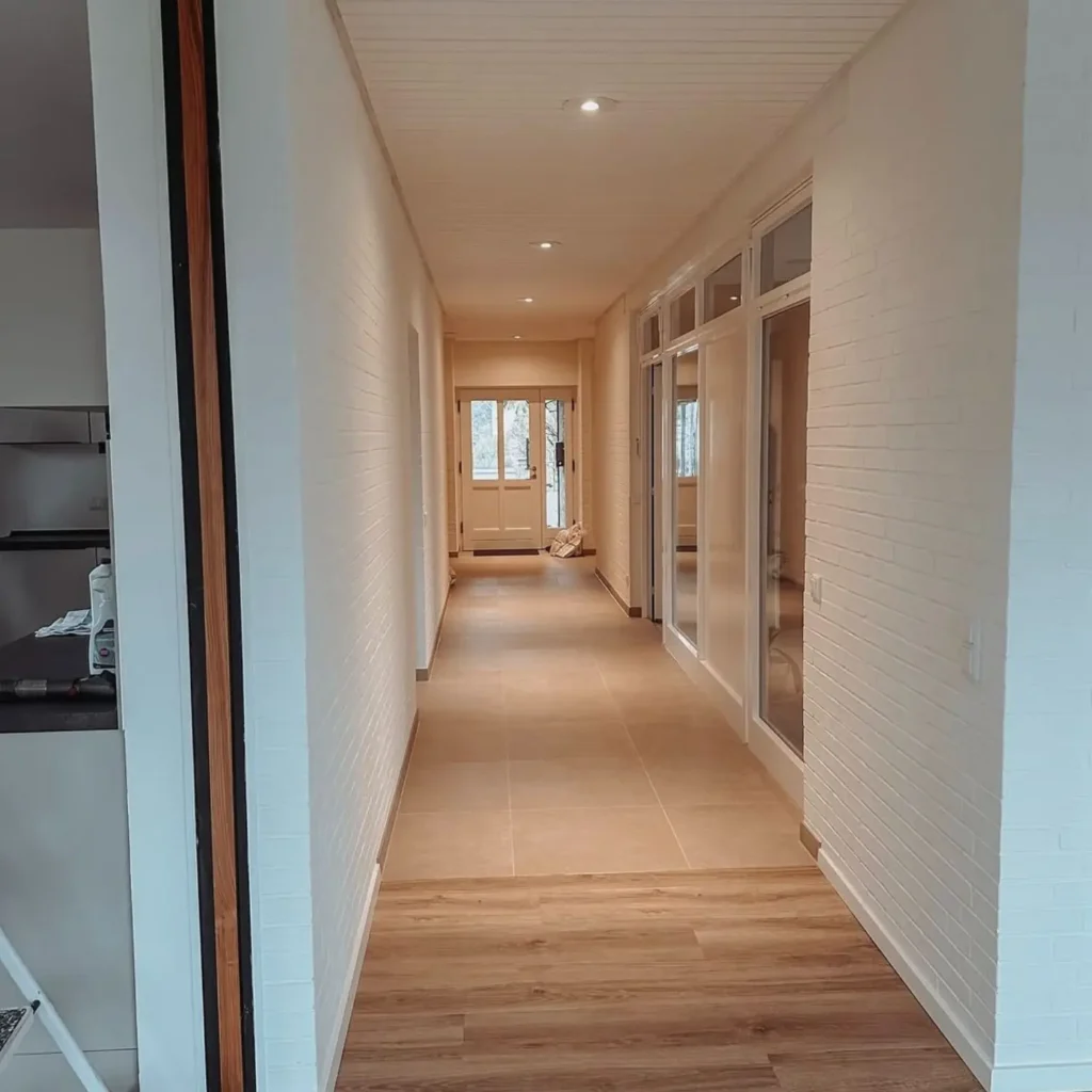 Renovated hallway in Zurich home with modern flooring, fresh paint, and recessed lighting.
