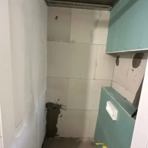 Bathroom renovation before works in Zurich apartment, with unfinished walls and plumbing installation.