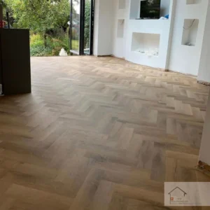 Renovated living room in Zurich with new wooden herringbone flooring and modern interior design.