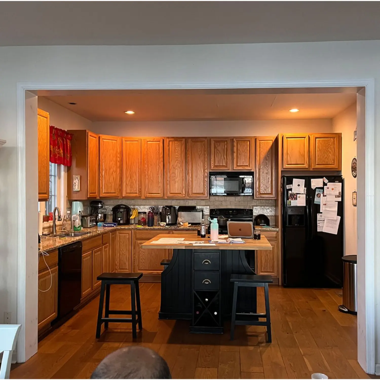 Old kitchen in Zurich before renovation with wooden cabinets, dark countertops, and outdated design.