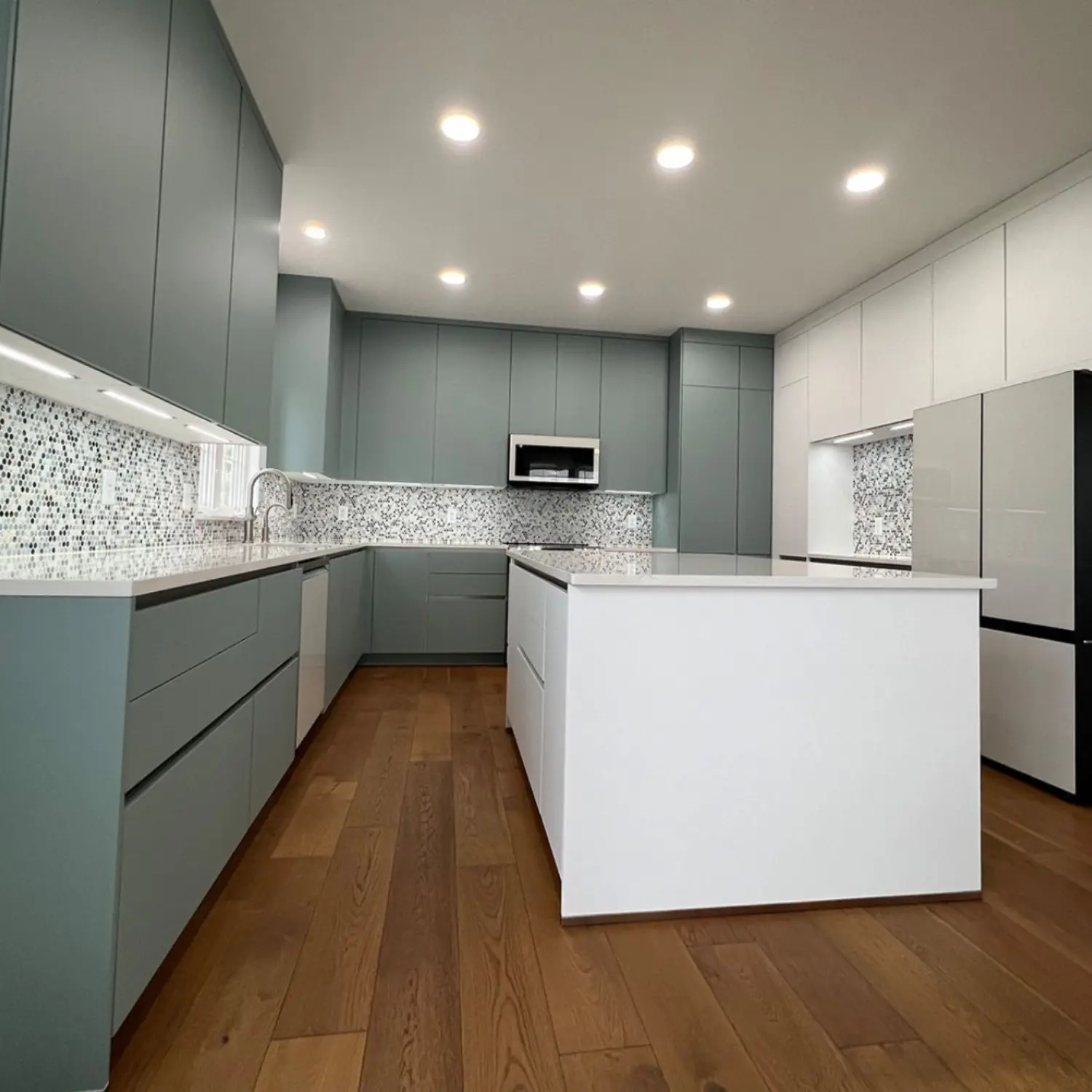 Modern kitchen renovation in Zurich with central island, custom cabinets, and mosaic backsplash.