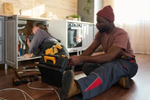 Zwei Handwerker bei Reparaturarbeiten in einer modernen Küche in Zürich
