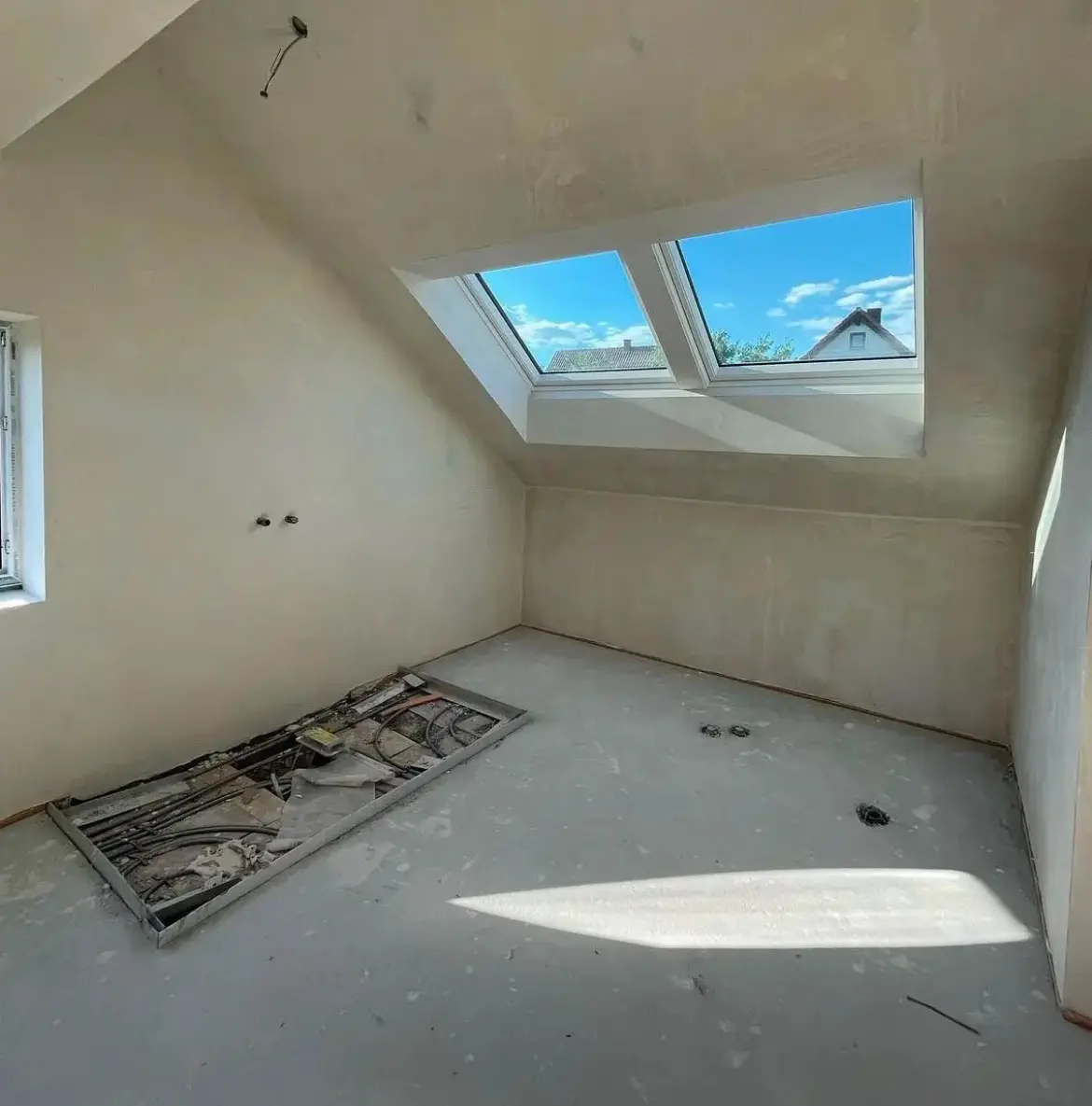 Badsanierung vor den Arbeiten in einer Zürcher Wohnung mit Dachfenster und unfertigem Boden.