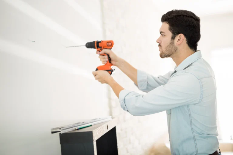 Mieter bohrt eine Wand in einer Schweizer Mietwohnung – Regeln für Bohrlöcher in Zürich, Zug und St. Gallen.