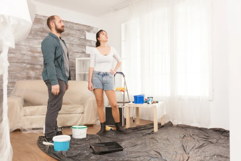 Mieter in Zürich prüfen mögliche Schimmel- und Feuchtigkeitsschäden an einer Wohnzimmerwand