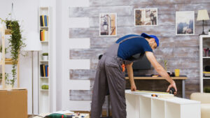 English speaking handyman assembling furniture in a Zurich apartment using measuring tape and tools